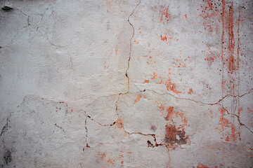 Worn grunge wall with stucco and crack.