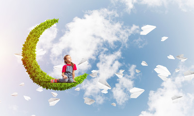 Concept of careless happy childhood with girl on green moon