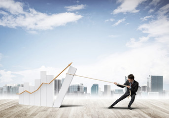 Obraz premium Man pulling with effort big pulling rope graph, as a symbol of financial growth