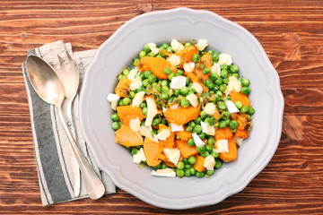 Warm salad with roasted pumpkin, peas and cheese brie