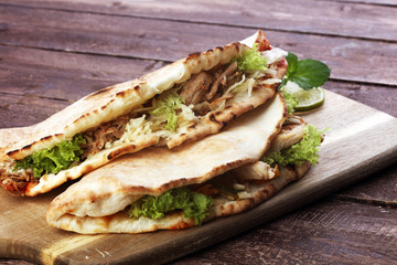 Delicious kebab sandwiches on wooden table