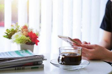 Woman leaning on the bar counter and text messaging with her mobile, hands close up