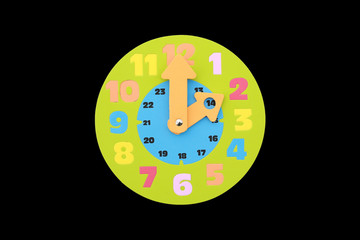 2 O'clock round toy clock isolated on black background.