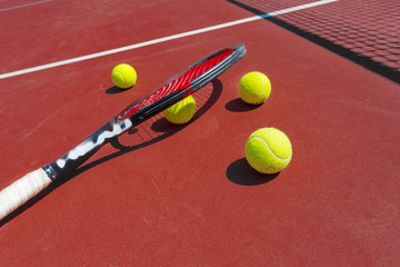 Tennis balls and racket on the grass court