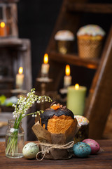 Festive cupcake with a bouquet of valley lilies on a background of candles