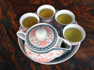 Flower pattern tea set on wooden table. on top angle. a set of cup and pot, typically of china or...