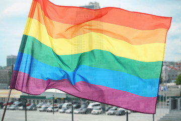 Gay flag on modern business center background