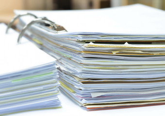 Stack of papers and documents in document file on white table at workplace,business concept,office supplies.