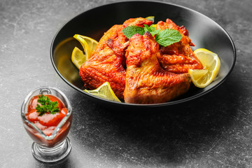 Delicious wings with sauce for chicken on kitchen table