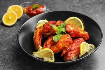 Delicious wings with sauce for chicken on kitchen table