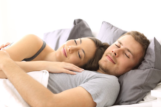 Happy couple sleeping together on a bed