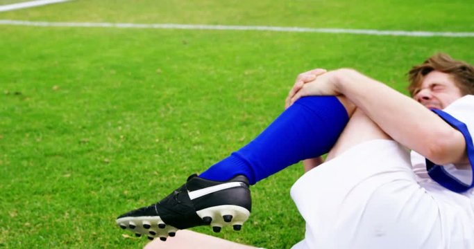 Injured football player lying on grass