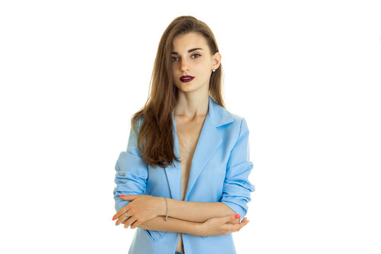 Cute business girl in blue jacket without bra looking at the camera