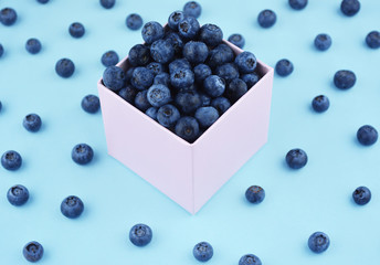Freshly picked blueberries on blue background.
