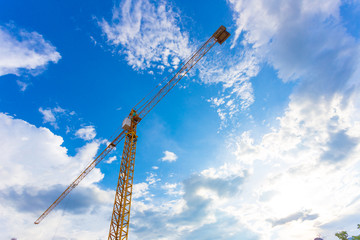 buildings under construction and cranes under a blue sky
