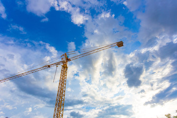 buildings under construction and cranes under a blue sky