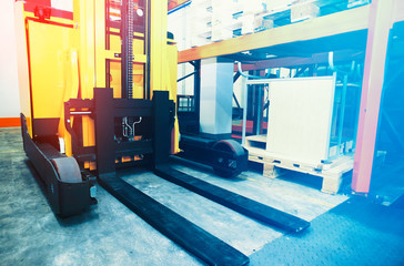 Shelves, racks and forklift  with pallets in distribution warehouse interior