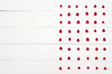 Top view of lines from sweet fresh organic raspberries, free space. Fresh berries on white wooden background with blank space. Summer and healthy food concept flat lay
