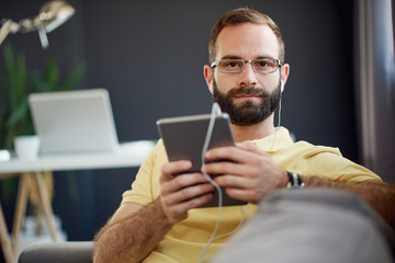 Fototapeta na wymiar Caucasian freelancer using tablet device in modern home office