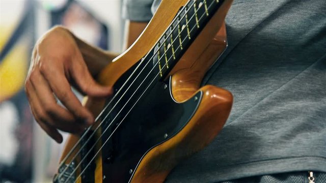 Man Lead Guitarist Playing On Electrical Bass Guitar. Close Up