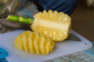 Pineapple fruit cut on chopping board