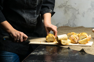 woman sliced French fresh bread baguette with poolish, shallow dof