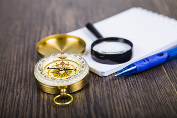 Compass, magnifying glass and  notebook