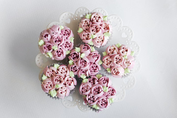 gourmet pink decorated cupcakes on table