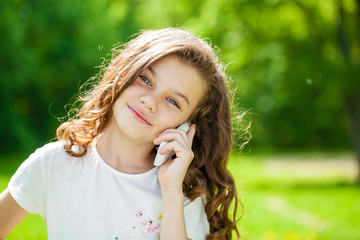 Portrait of a beautiful young little girl calling by phone