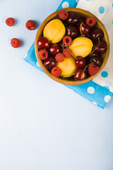 Ripe berries in a plate on a wooden table.
