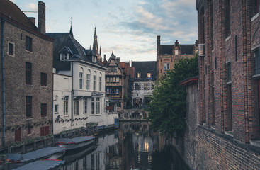 Evening view of typical canal of medieval city of Brugge with traditional houses