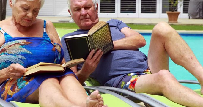 Senior couple reading books on lounge chair