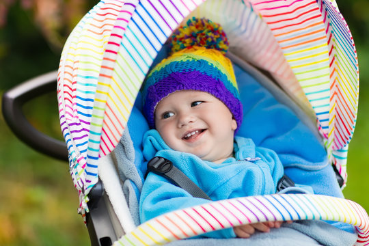 Baby boy in stroller in autumn park