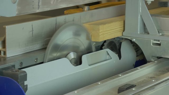Circular saw cuts wooden beam.