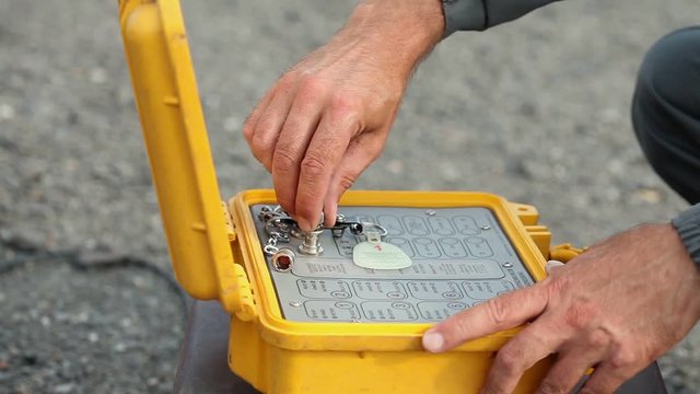 Blast in open cast mining quarry, working presses explosive device