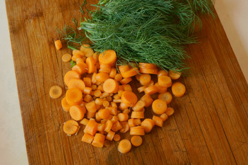 Obraz na płótnie Canvas carrots and dill on a cutting board made of wood