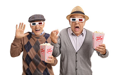 Fototapeta premium Terrified seniors with 3D glasses and popcorn