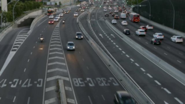 Blurred evening urban traffic scene with a top and rear view access roads to Barcelona.With 
cars stopped and then set in motion.Time Lapse.