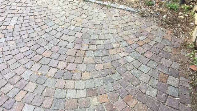 Persona cammina, scende le scale in citt&agrave; con ciottoli
