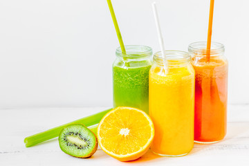 Fresh detox juices in glass bottles on white background