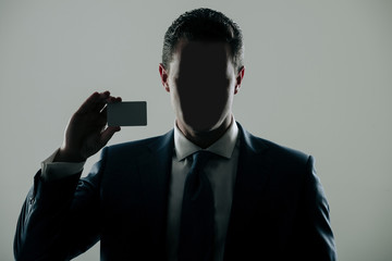 Faceless man holding blank business or bank card