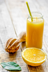 freshly squeezed orange juice in glass bottle on wooden backgrou