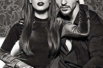 Sexy woman with red lips embrace young rich man black and white