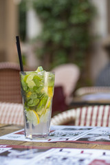 A glass of cold mint lemonade with lemon and lime