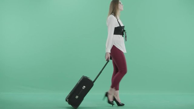 a young woman in glasses is carrying a luggage