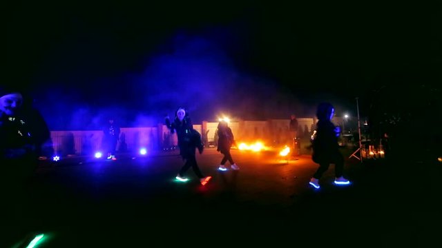 Fireworks. Fire show. Boys and girls dance in shoes that glow in the night
