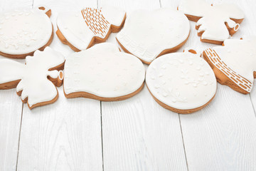 White glazed Christmas cookies on white wooden background