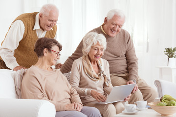 Elderly couples looking at laptop