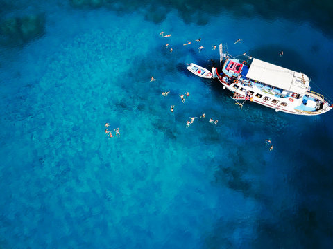 Top view of students on summer vacation jumping from the boat.