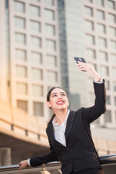 Modern smiling beautiful business woman using smart phone with copy space